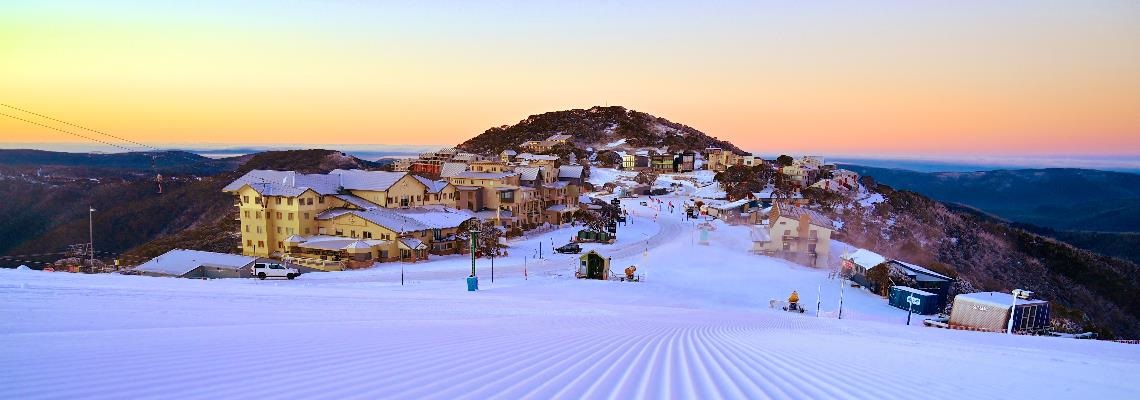 Mt Hotham Resort surrounded by groomed snow on sunrise